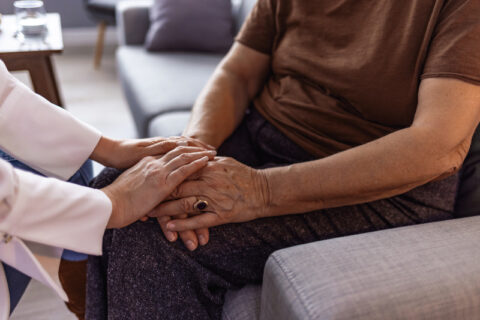 Cropped shot of a senior woman holding hands with a hospice nurse